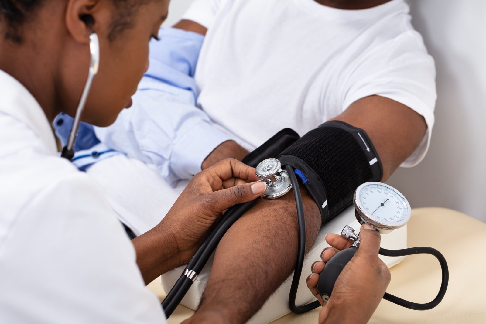 Black nurse treating a sick patient in a hospital